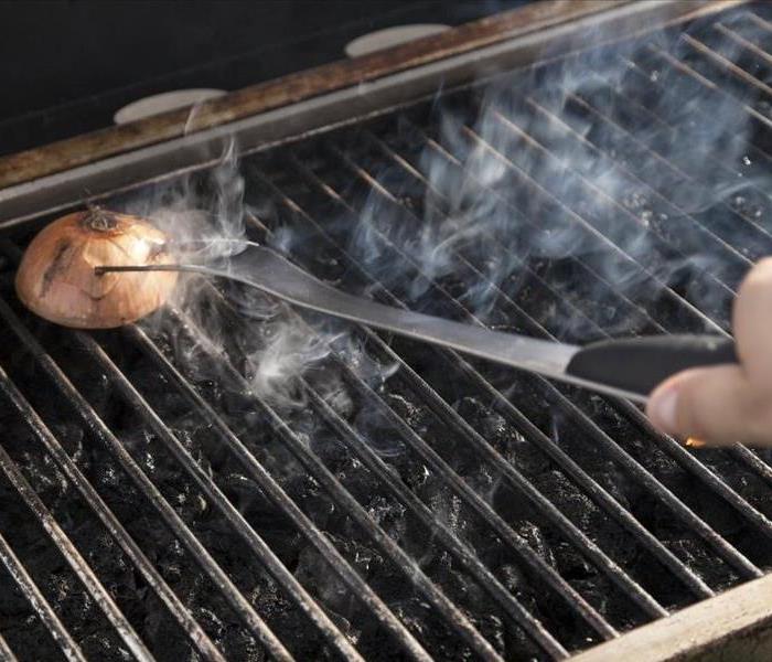 Grill being cleaned with a piece of onion