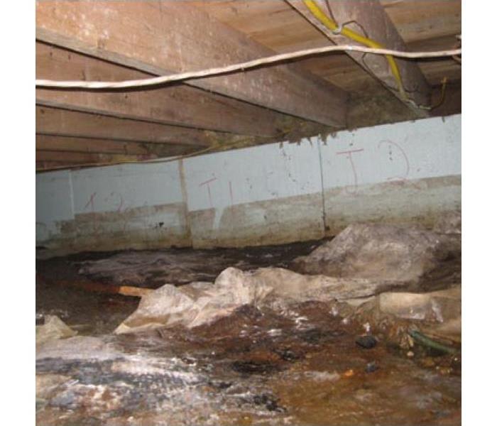 dark crawl space under home with standing water 